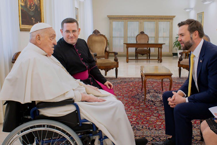 Pope Francis sits in a wheelchair talking with US vice-president J.D. Vance.